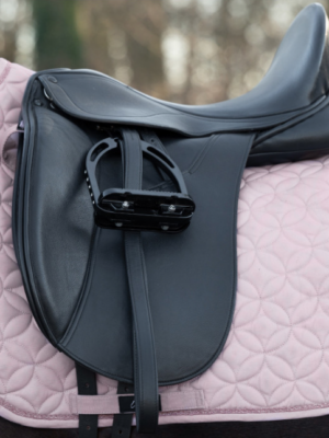 Offrez à votre cheval le confort et la sécurité qu'il mérite avec le tapis de selle HKM ! Doté de pattes d'attache velcro pour un ajustement facile et sécurisé, ce tapis est conçu en matière respirante pour garantir un confort optimal. Sa forme anatomique s’adapte parfaitement, tandis que les surpiqûres élégantes et le cordon décoratif ajoutent une touche de style unique. Prêt à briller sur le terrain ! De Cuirs et de Crins