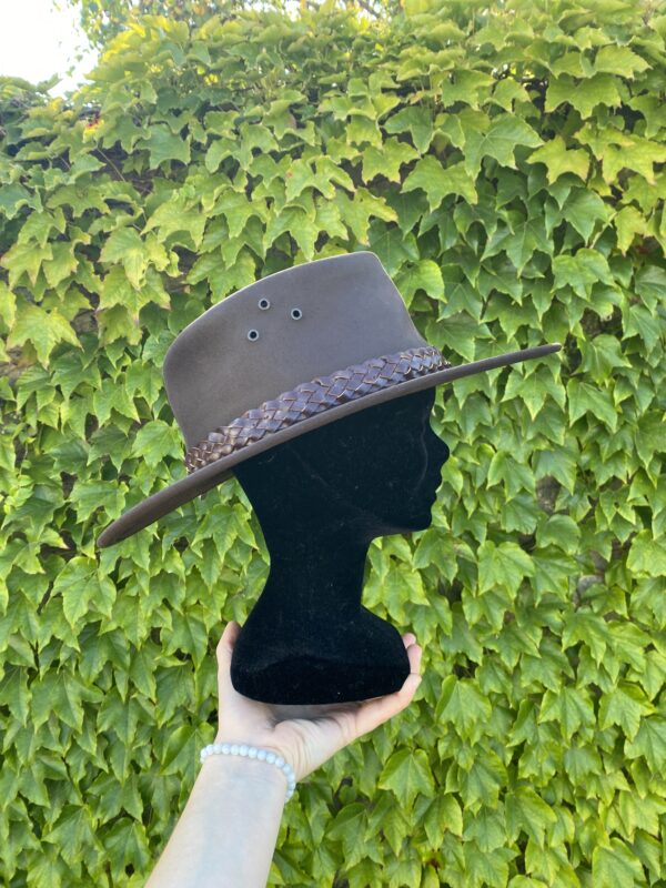 Ajoutez une touche de style à votre tenue avec ce chapeau de cowboy en cuir australien marron. Fabriqué en vachette, il est solide, étanche et résistant au soleil.